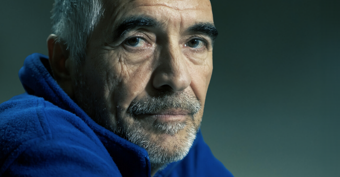 Greying man, looking at the camera.