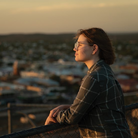 girl overlooking a city at dusk