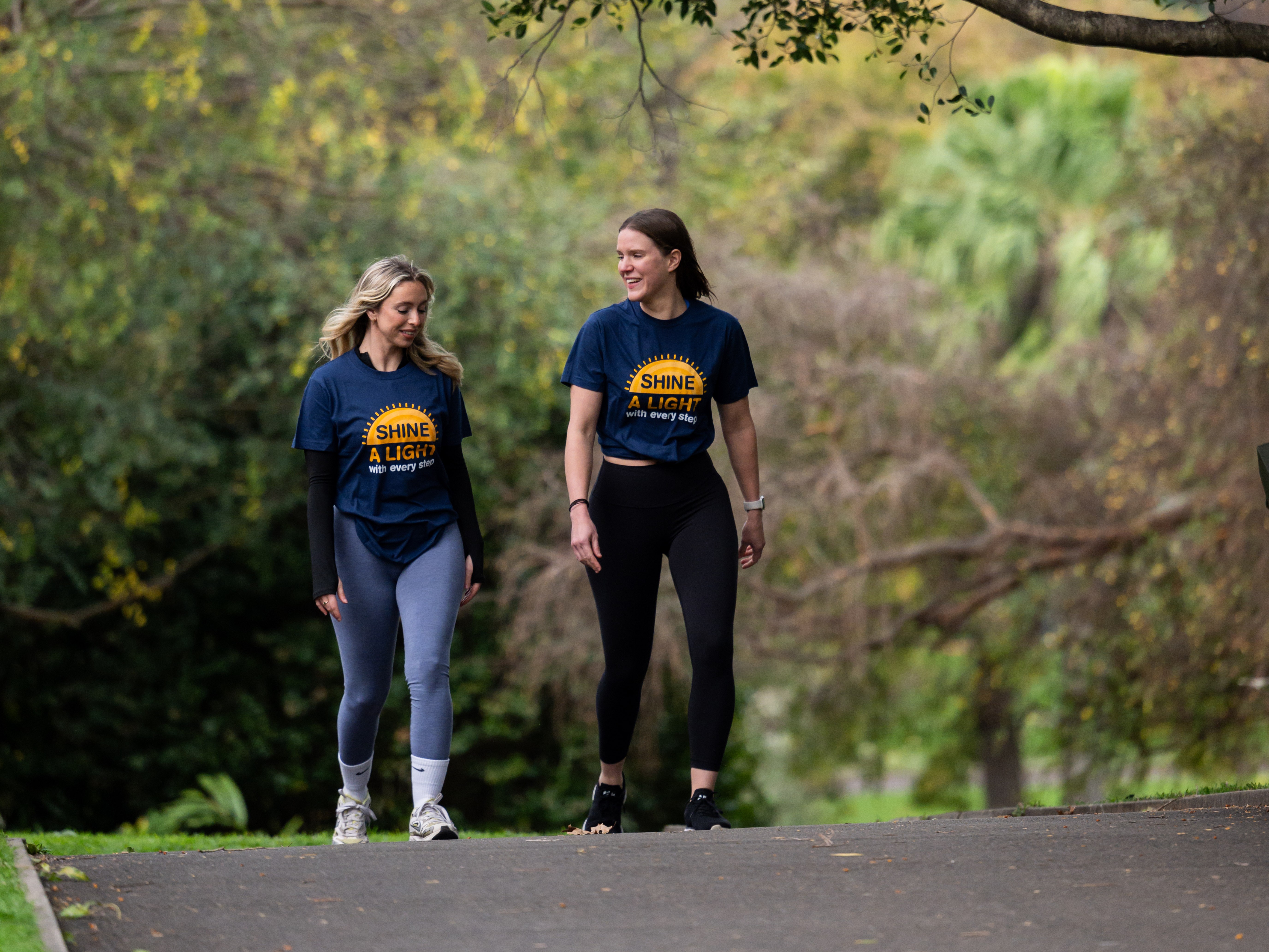 Two volunteers for the fundraiser 'Shine a light' walking in the park.