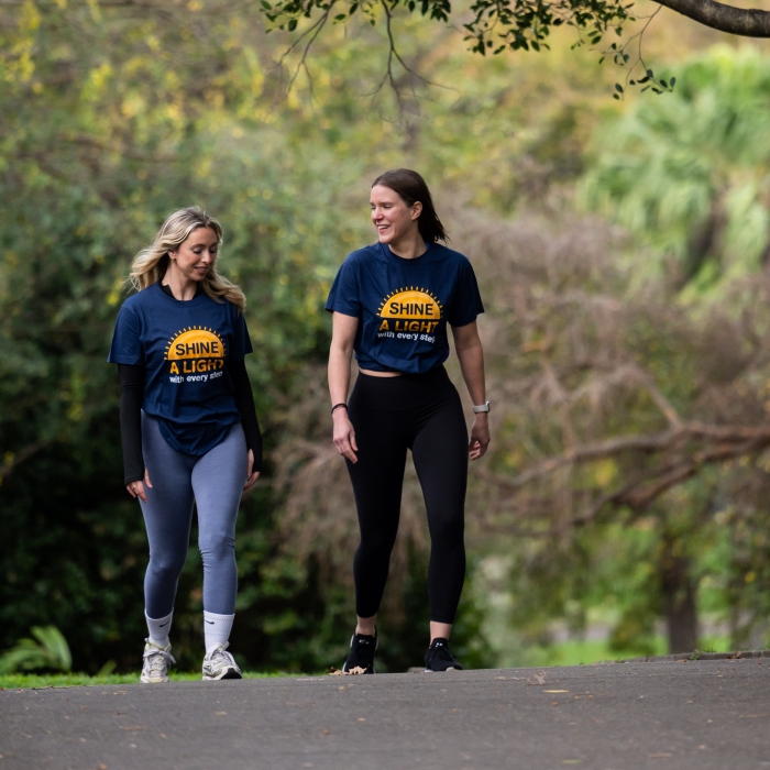 Two volunteers for the fundraiser 'Shine a light' walking in the park.