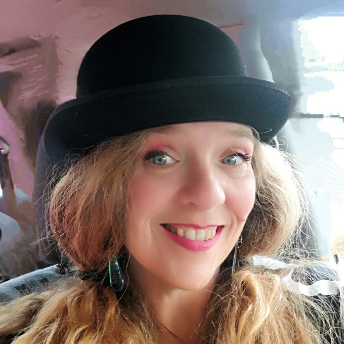 woman with long blonde hair wearing a black hat