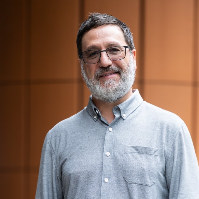 Tim Sharp, wearing a grey button down shirt, standing on the steps of an office building in Sydney CBD